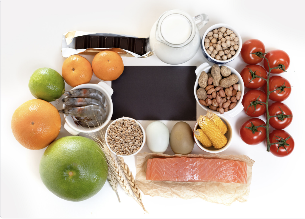 Healthy foods placed on a white table. The elimination diet cuts out most of the inflammatory foods in our diet for at least 30 days.