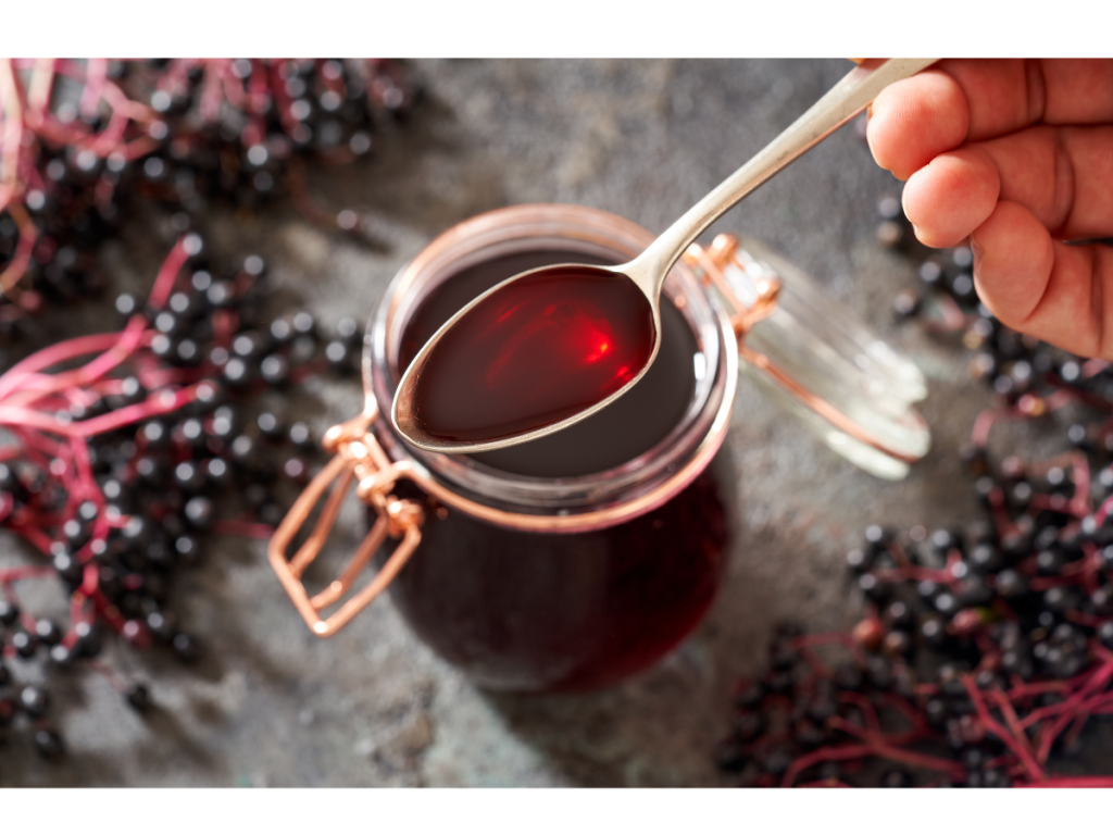 Elderberries surrounding a jar of elderberry syrup and benefits include immune boosting properties