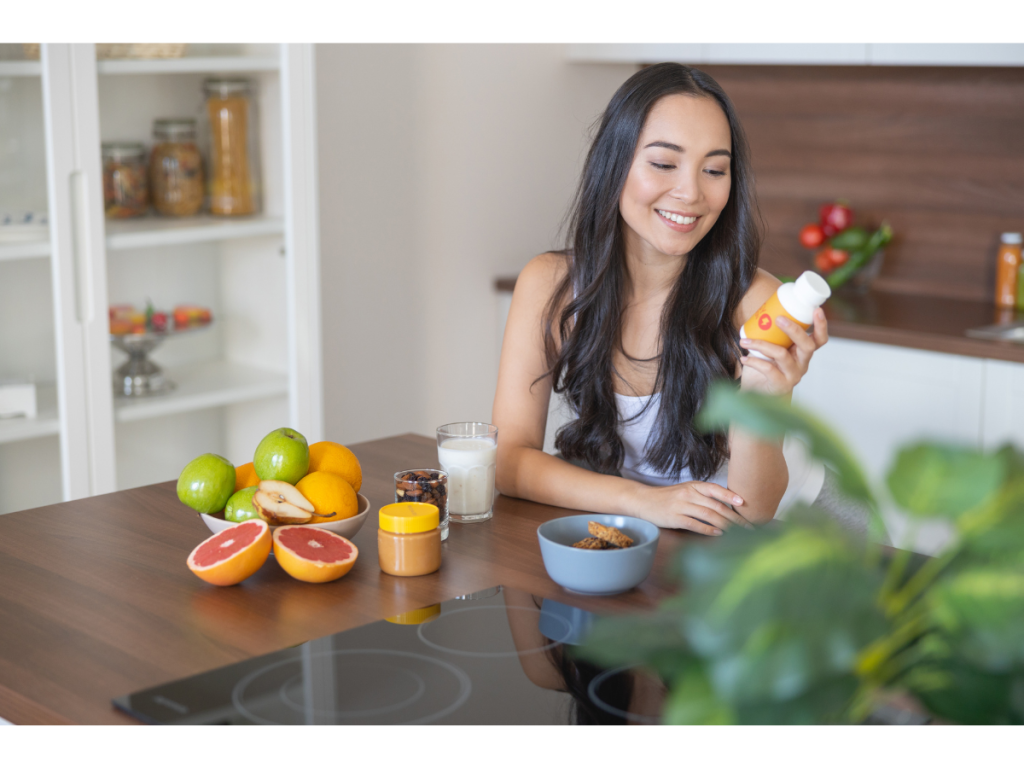 Happy woman with long brown hair taking supplements.